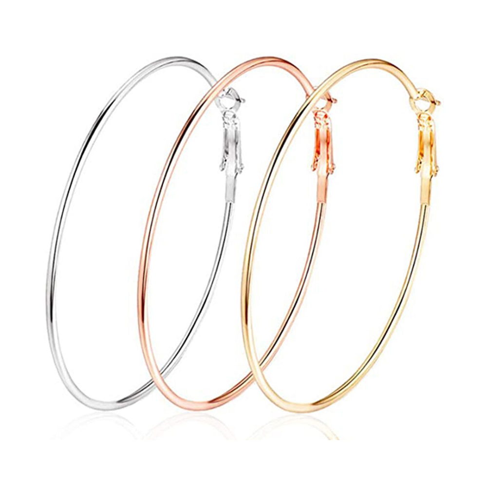 Small gold-tone hoop earrings in a range of shapes laid out on a plain light background