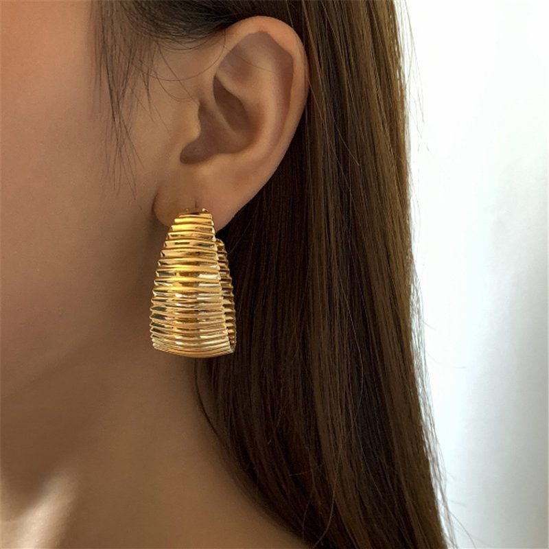 A wide multi-wire gold-tone hoop earring worn on the ear, shown to indicate the drop length against the jawline