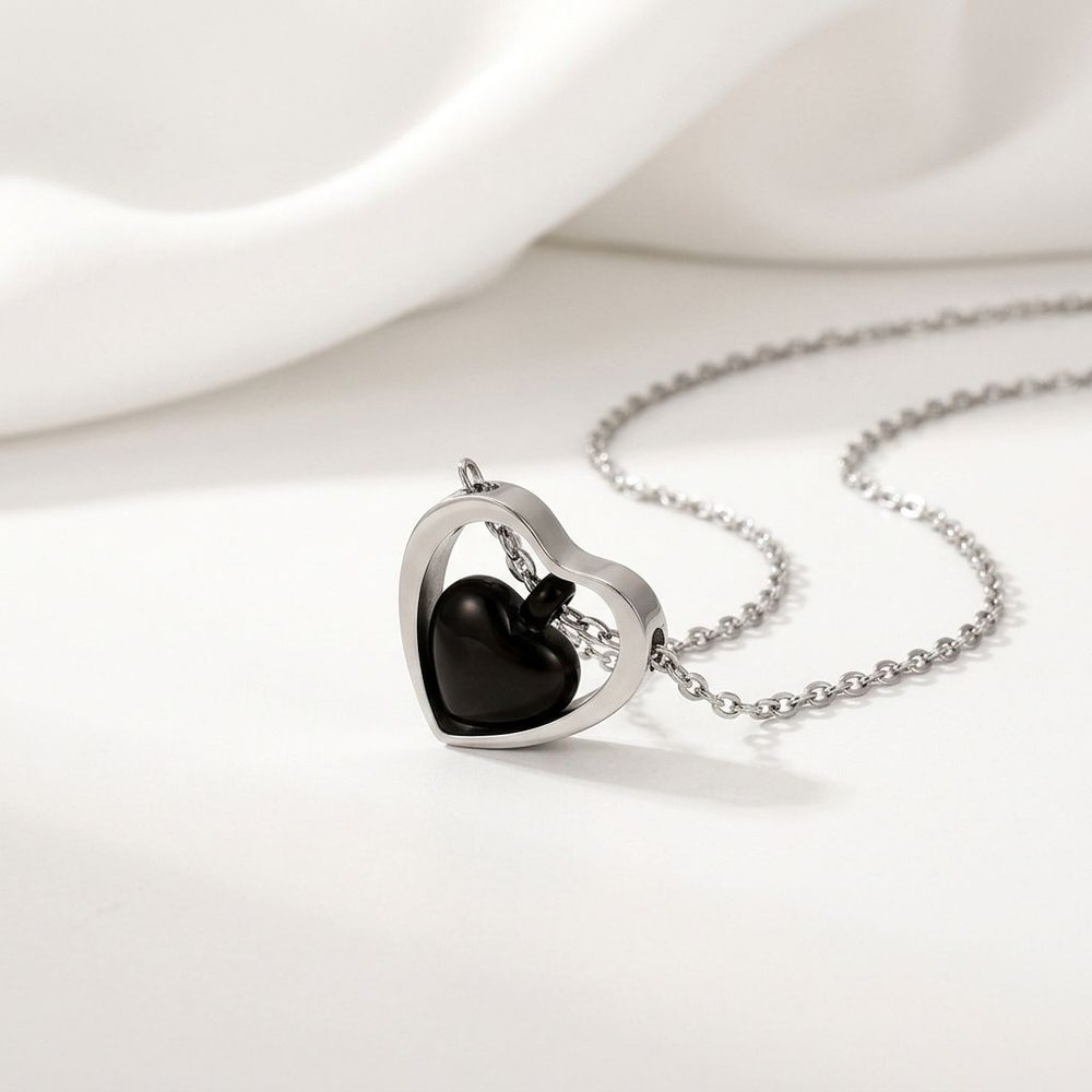 Heart-shaped stainless steel memorial urn pendant on a fine chain, holding a small keepsake compartment